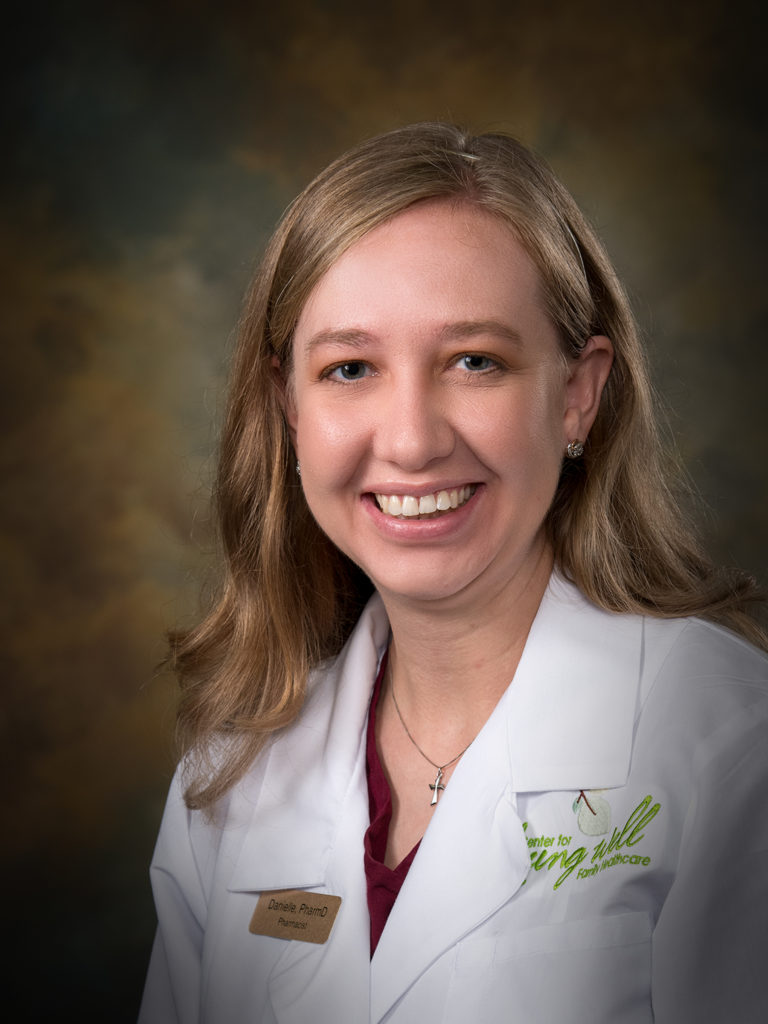 Headshot of Danielle Bohrer, pharmacist for the Center for Living Well - Epcot, wearing a white lab coat